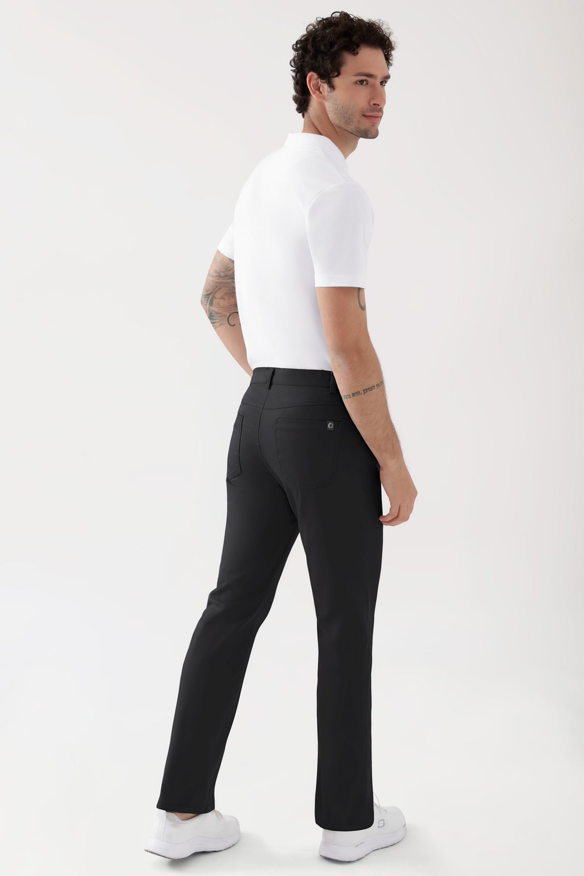 Mann in einem weißen Poloshirt und einer schwarzen COMFY FLEX 5-Pocket Hose Herren – gerades Bein, schwarz (5-Pocket-Hose mit geradem Bein).