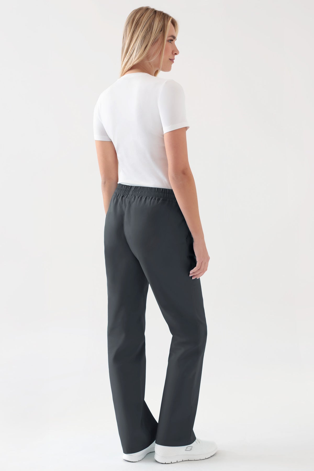 Eine Frau, die ein weißes T-Shirt und eine Hose von JUST STRONG für Damen – Gummibund, anthrazit, charcoal grey – mit bequemem Gummibund und Seitentaschen trägt.