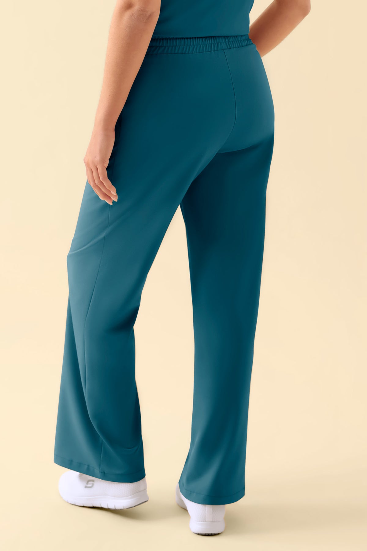 Rückansicht der türkisfarbenen KAERE Hose Damen – eine Scrub-Hose in Petrol mit weitem Bein und lässiger, weiter Passform., Rückansicht