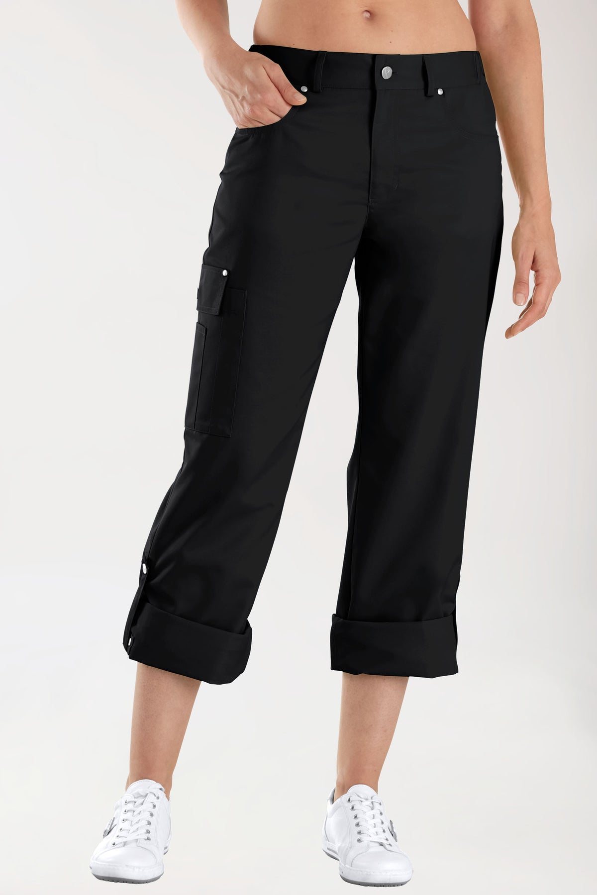 Schwarze JUST STRONG Hose Unisex – Teilgummibund, schwarz, verkürzte 5-Pocket-Cargohose mit Seitentasche und umgeschlagenen Hosenbeinen, kombiniert mit weißen Sneakers.