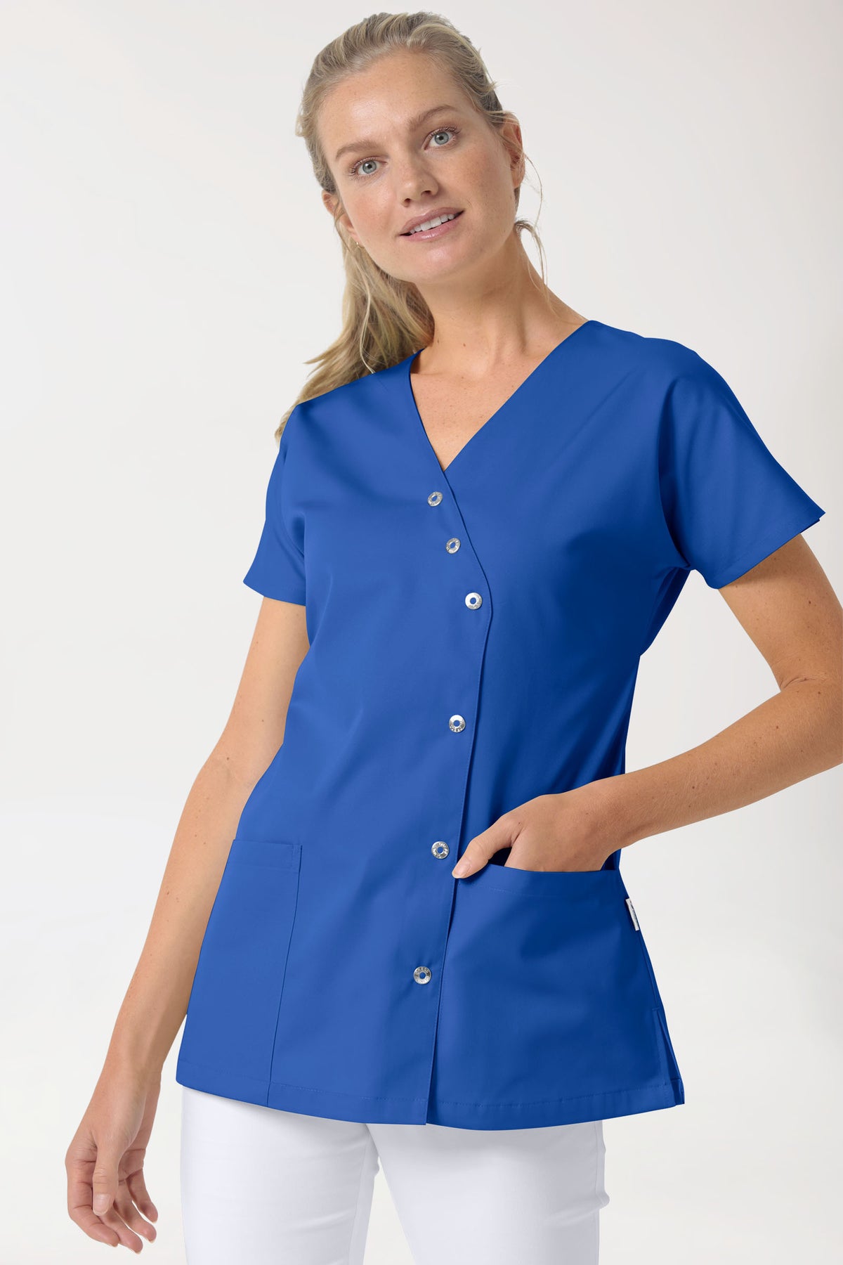 A CLINIC DRESS Beauty Kasack Damen – asymmetrische Druckknopfleiste, königsblau: ein königsblaues Kasack-Oberteil im Wickelstil mit V-Ausschnitt, asymmetrischem Druckknopfverschluss, Fledermausärmeln und zwei Taschen.