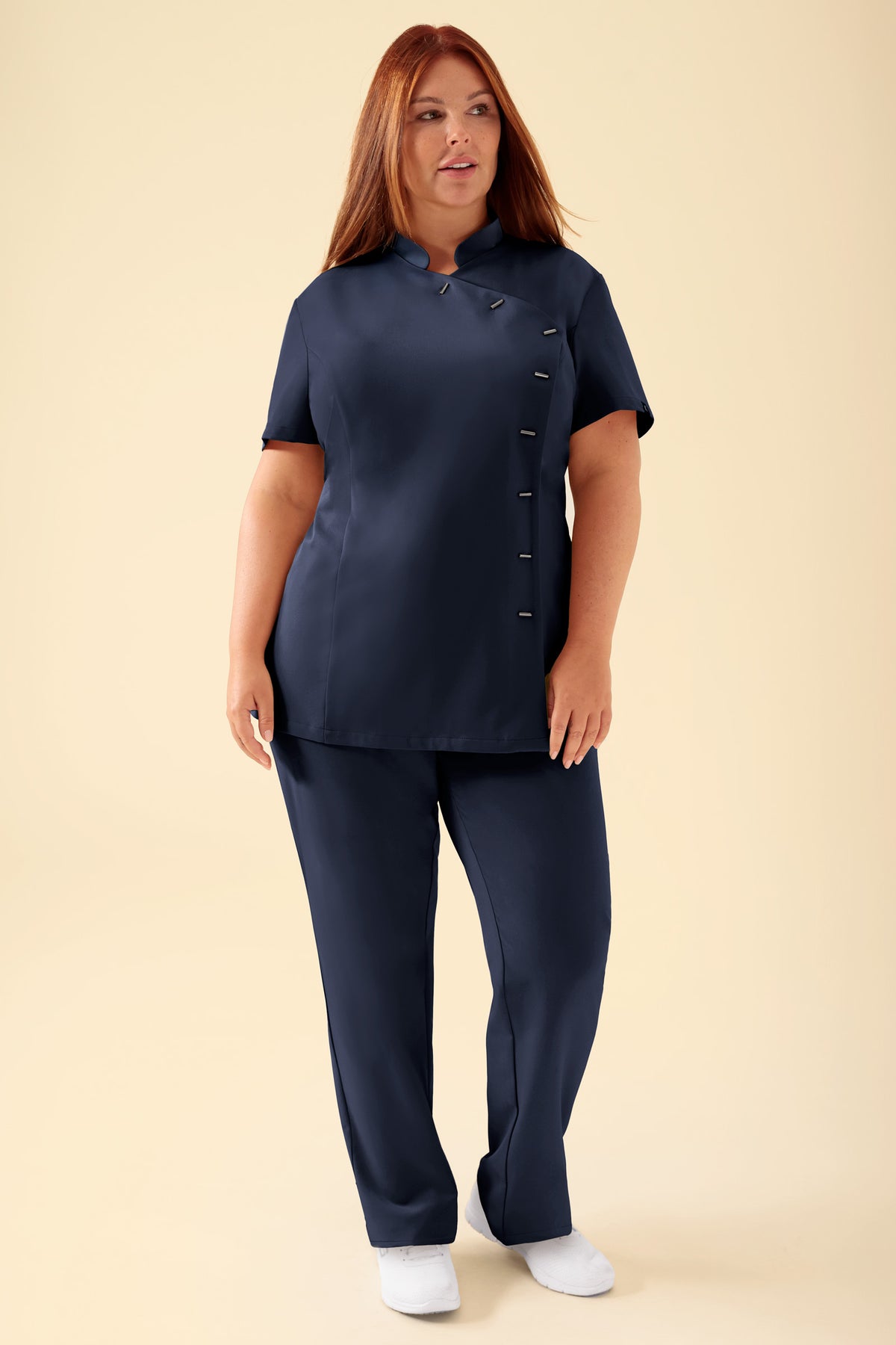 KAERE Kasack für Damen – asymmetrische Knopfleiste, marineblau: eine taillierte, marineblaue Tunika mit Stehkragen und asymmetrischer Knopfleiste, kombiniert mit einer passenden Hose., Vorderansicht Das Model ist 173 cm groß und trägt Größe XL