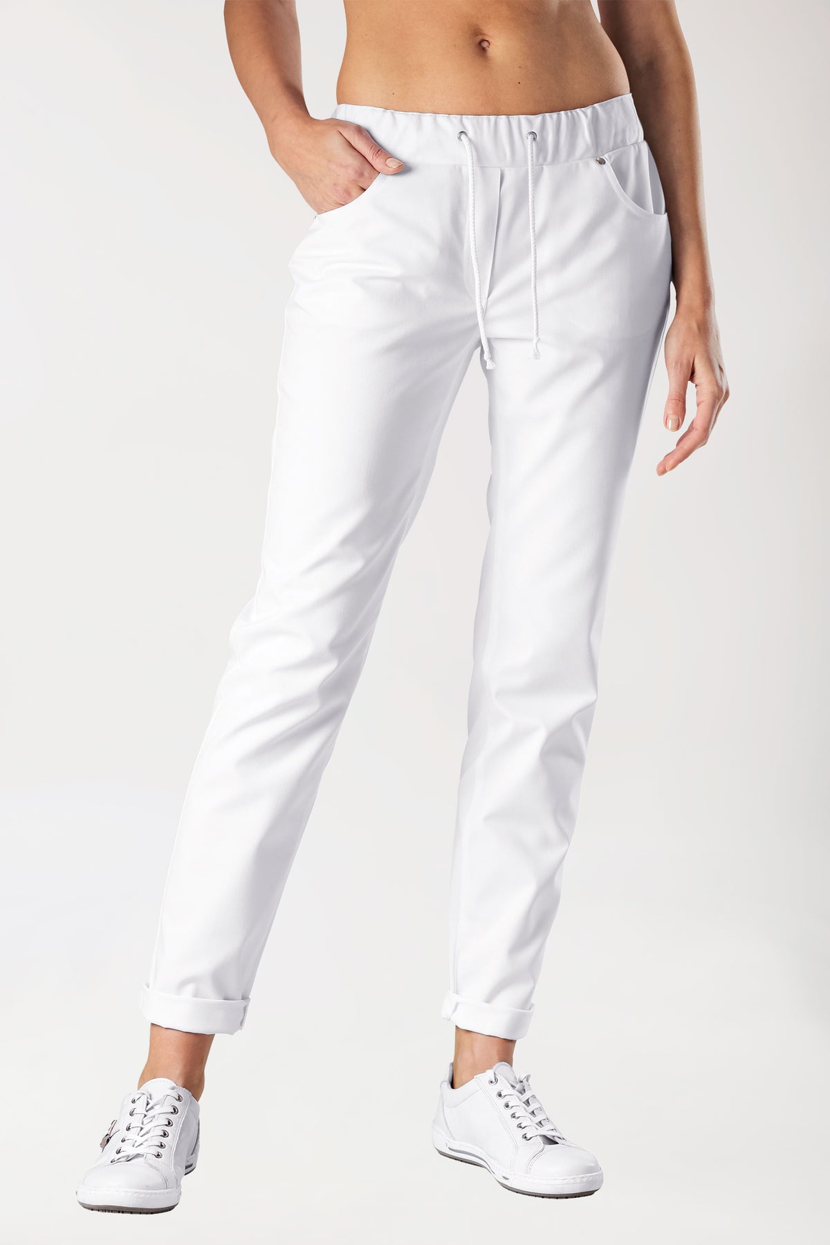 Weiße 5-Pocket-Stretchhose für Damen – im Jeans-Look, weiß, mit elastischem Kordelzug in der Taille und umgeschlagenen Säumen, kombiniert mit weißen Sneakers.