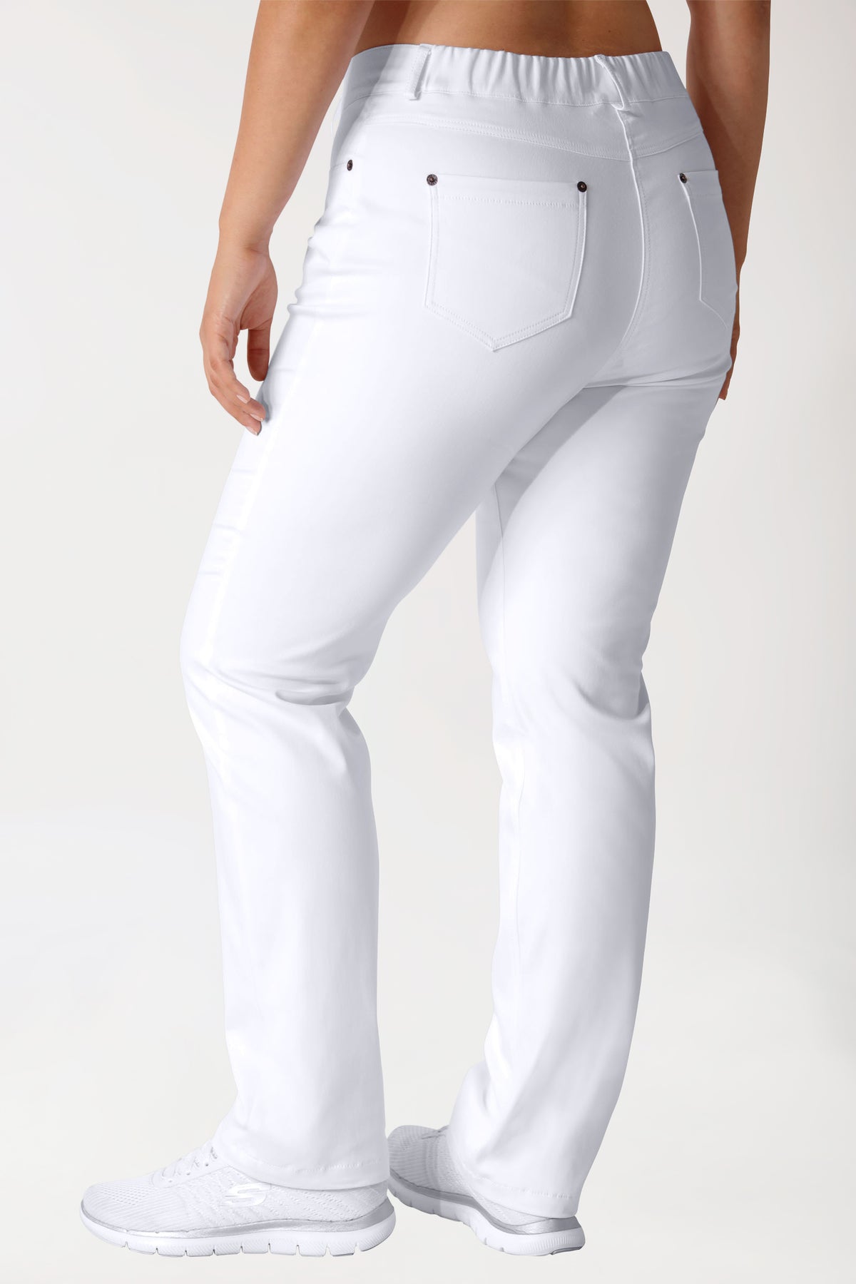 Eine Person, von hinten gesehen, die eine weiße Hose der Marke Curved Hose COMFY FLEX – 5-Pocket weiß mit einem elastischen Comfort Stretch-Bund sowie weiße Sneaker trägt.