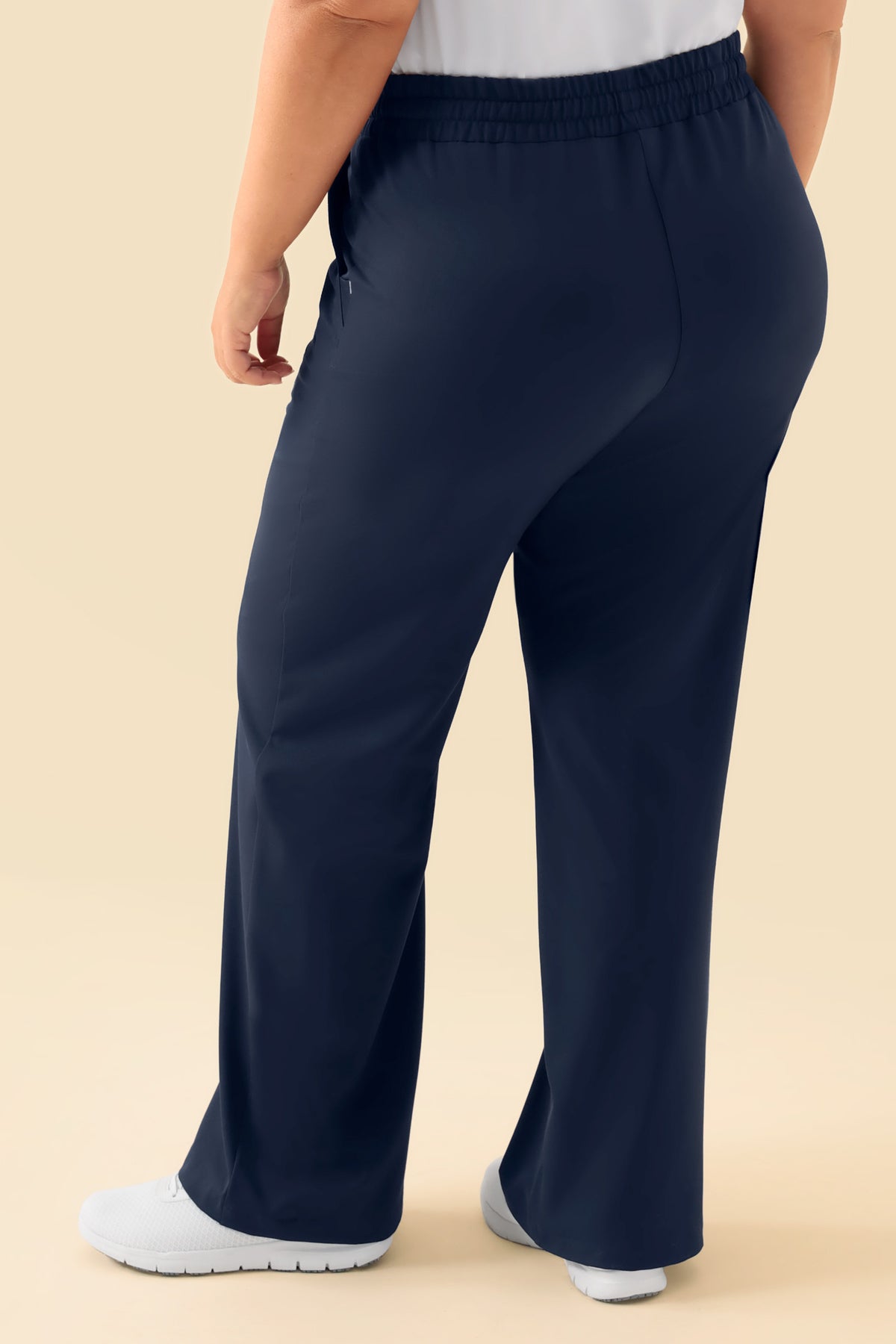 Rückansicht der marineblauen KAERE Hose Damen – eine Scrub-Hose mit weitem Bein in Marineblau, die sich durch einen bequemen weiten Schnitt und einen elastischen Bund auszeichnet., Rückansicht 