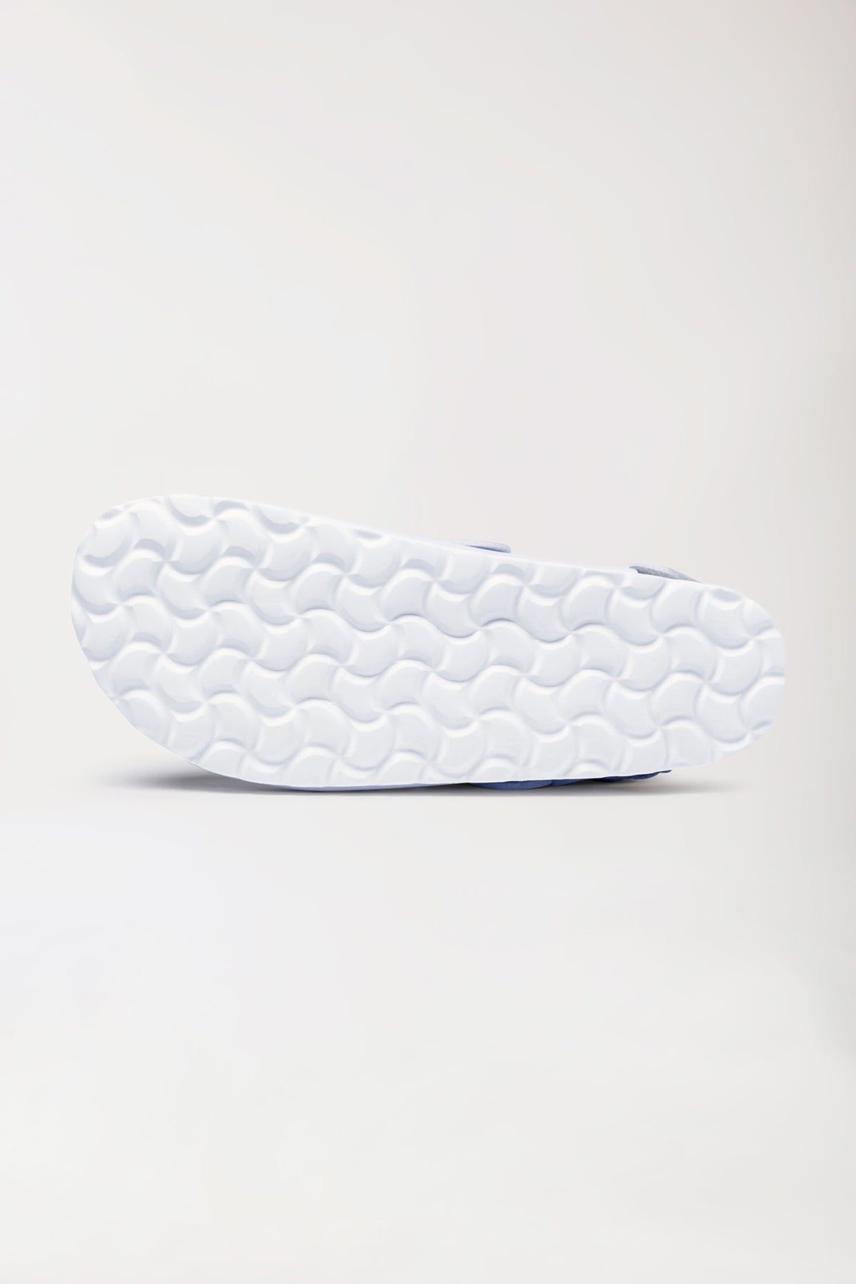 Ansicht von unten eines weißen CLINIC DRESS Damen-Clogs – Motivdruck – weiß mit gemustertem Obermaterial, Riemen aus Kunststoff und einer strukturierten Gummisohle mit Wellenmuster., Rückansicht 