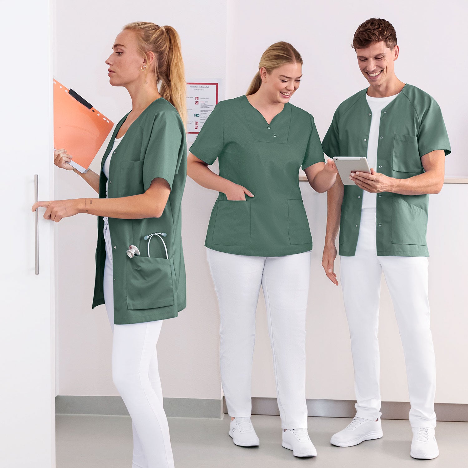 Teamaufnahme 3 Pflegekräfte in dunkelgrünen CORE Kasacks.