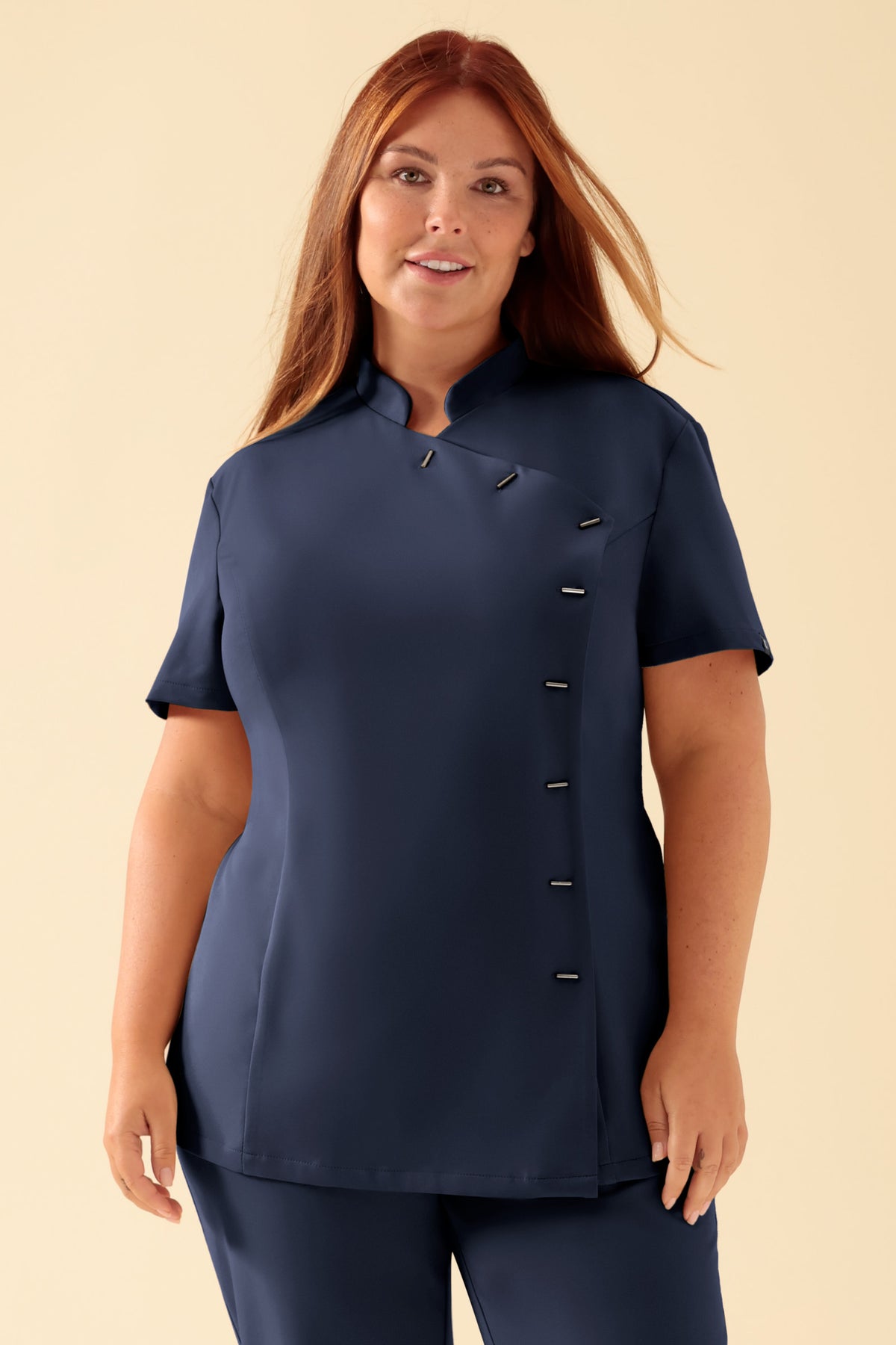 Eine marineblaue, kurzärmelige KAERE Kasack-Tunika für Damen mit Stehkragen, taillierter Passform und asymmetrischem Knopfverschluss.