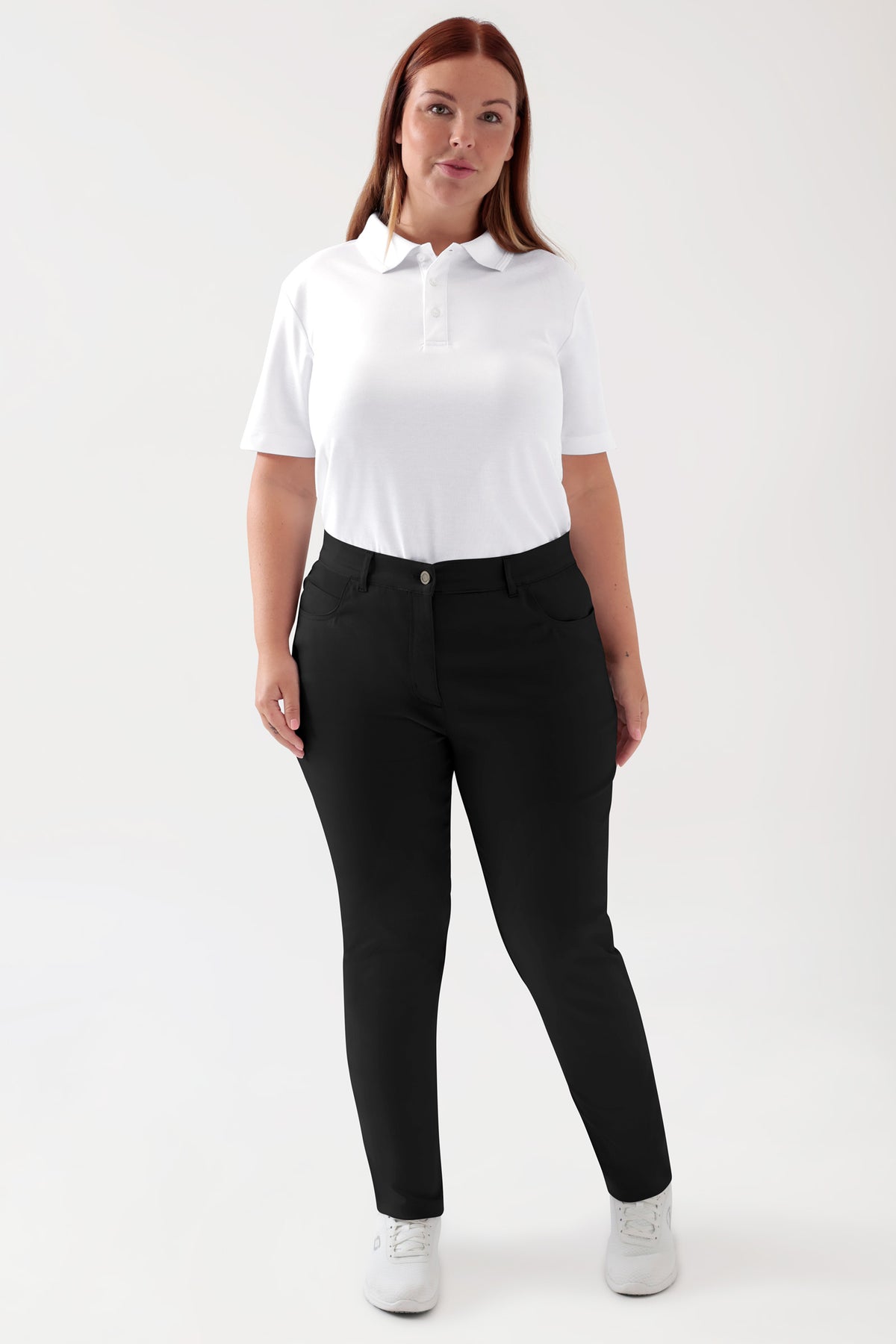 Eine Frau, die ein weißes Polohemd und eine schwarze Hose COMFY FLEX 5-Pocket Hose Damen – schlankes Bein schwarz mit Komfort-Stretch trägt., Vorderansicht Das Model ist 173 cm groß und trägt Größe 46