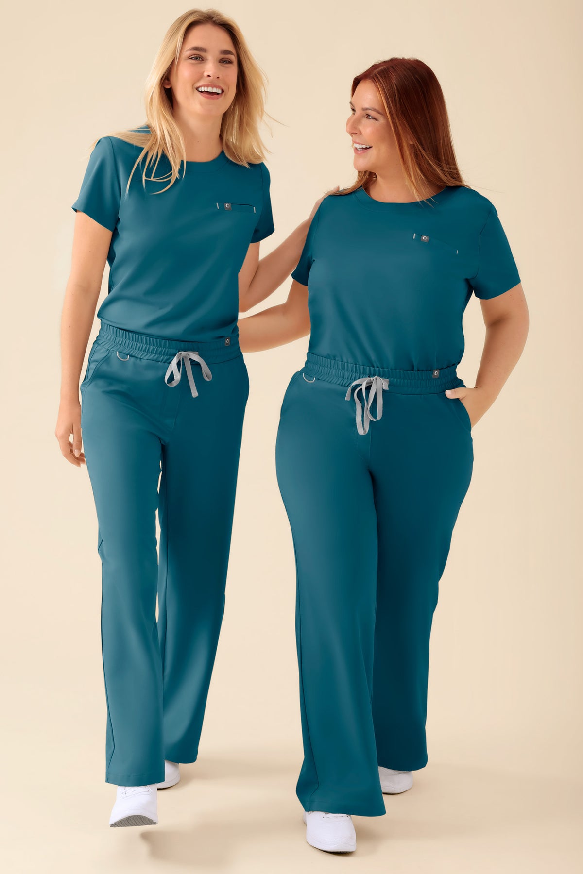 Zwei Frauen, die aufeinander abgestimmte, petrolfarbene KAERE-Hosen für Damen – mit weitem Bein – tragen, bestehend aus einem Oberteil und einer Hose mit bequemer, lockerer Passform und einem Kordelzug in der Taille., Vorderansicht 