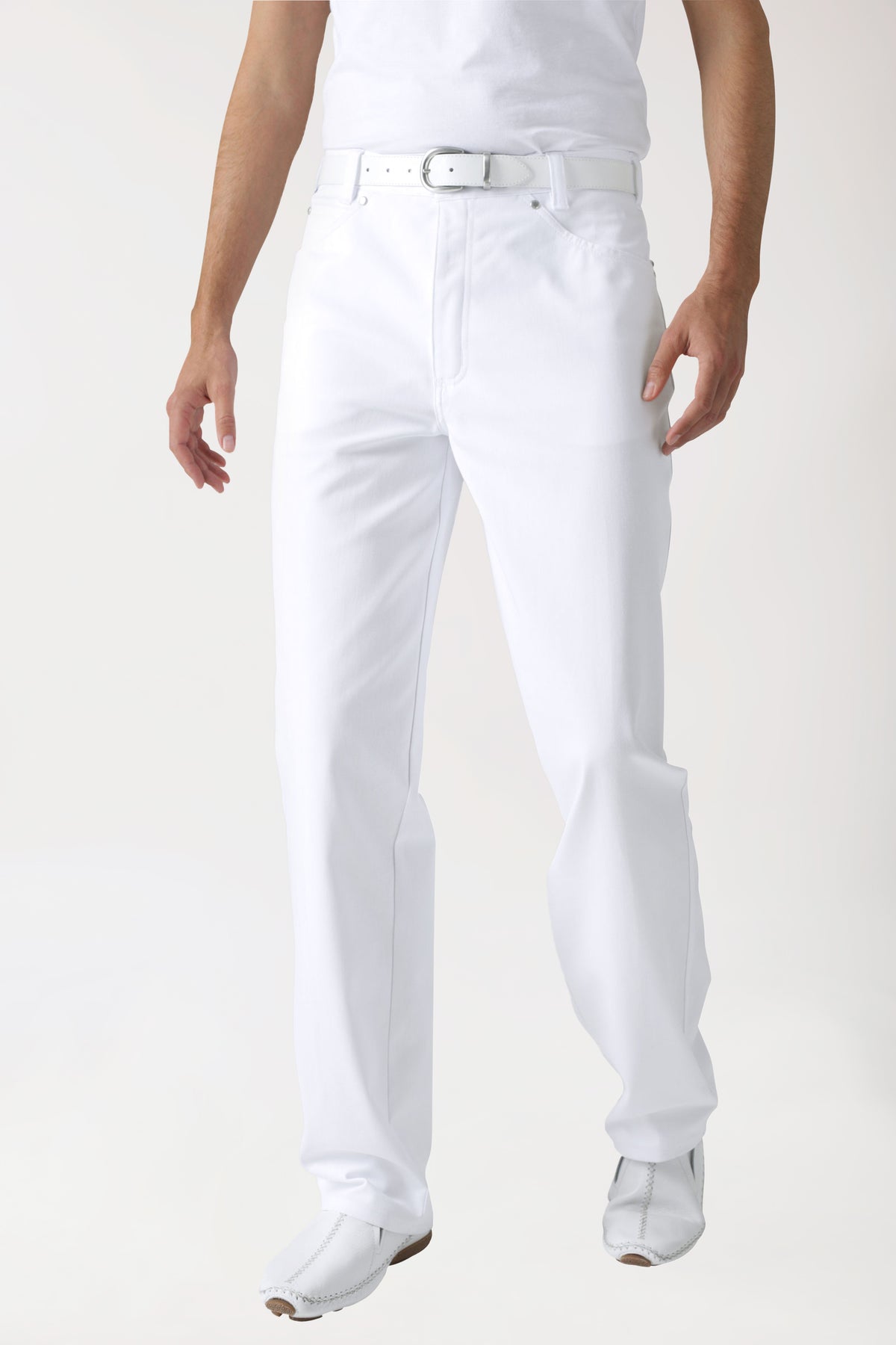 Ein Mann, der eine weiße, gerade geschnittene 5-Pocket-Hose im Jeans-Look und einen weißen Gürtel trägt.