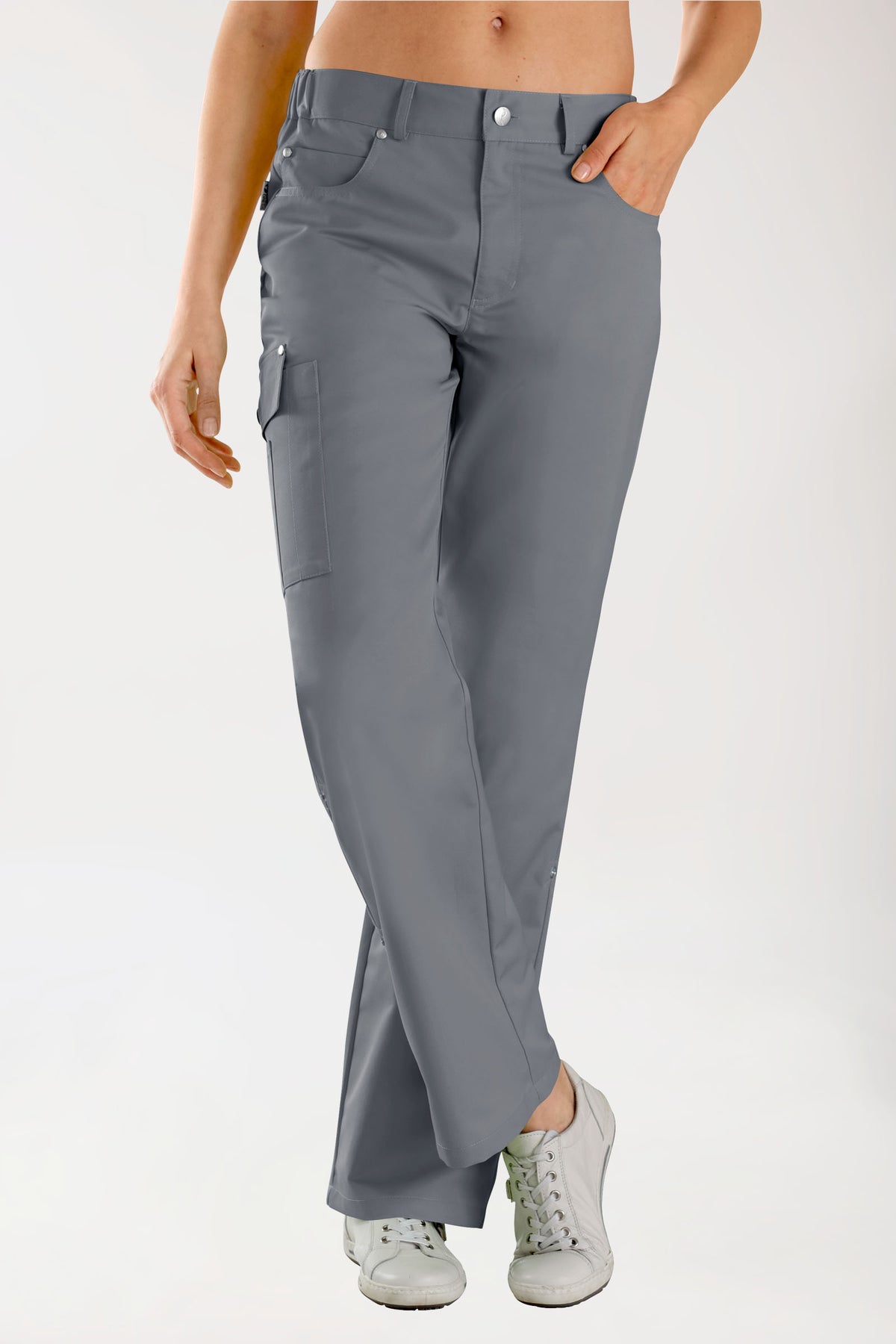 Person, die eine graue JUST STRONG Hose Unisex – Teilgummibund steingrau, eine 5-Pocket-Cargohose mit seitlichem Gummibund – und weiße Sneaker trägt.